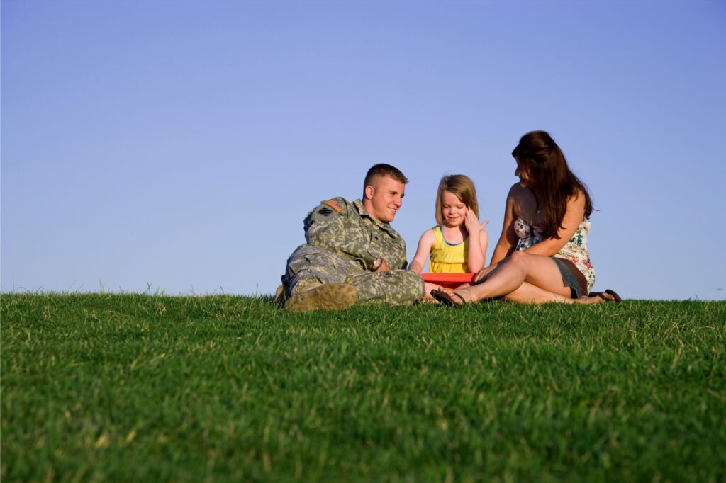 Veteran family hanging out in the grass.